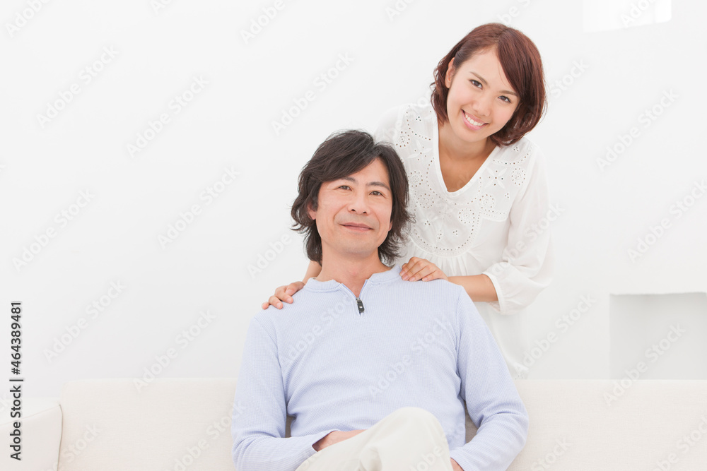 ソファーに座る父親と笑顔の娘 ソファーに座る父親と笑顔の娘