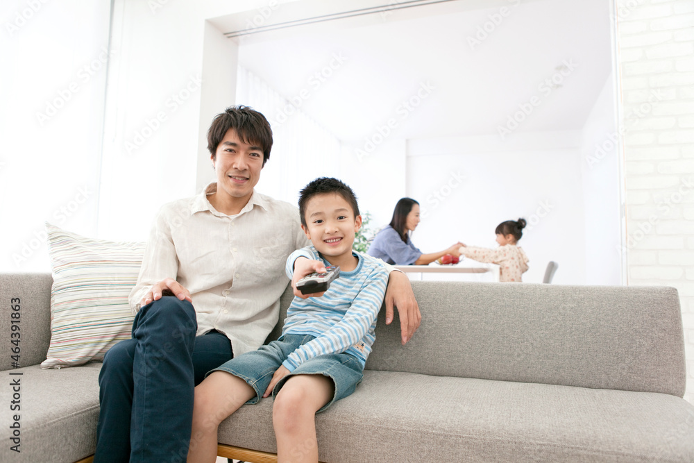 リモコンを操作する男の子と父親 リモコンを操作する男の子と父親