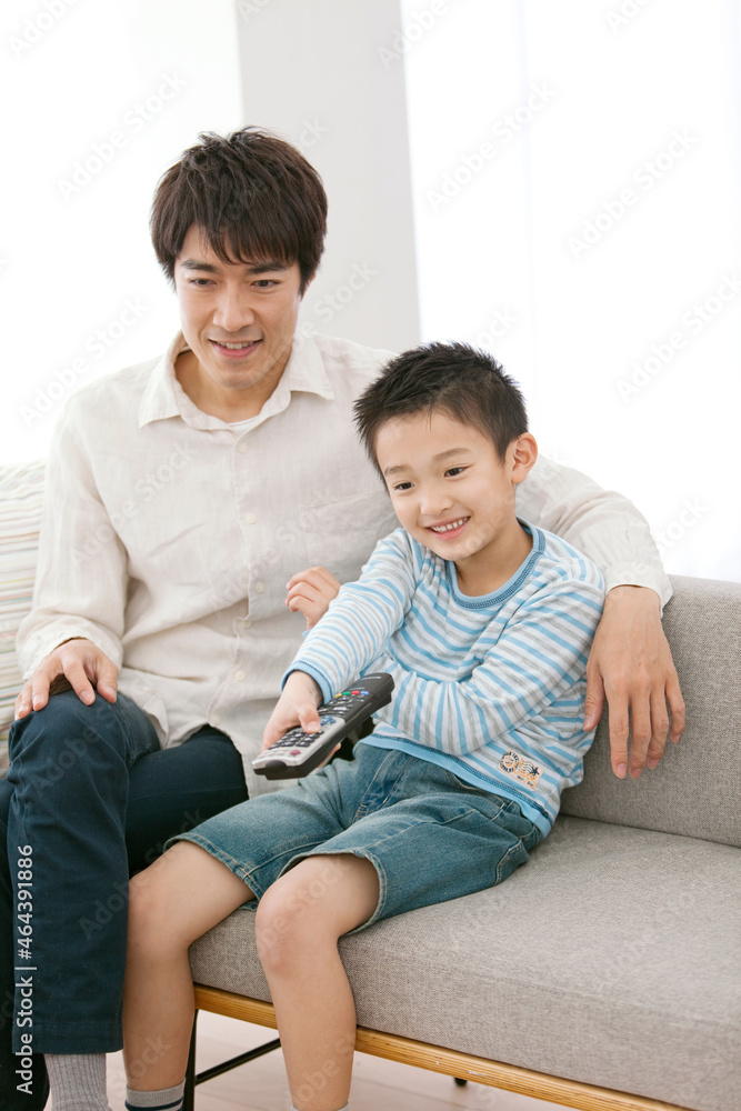リモコンを操作する男の子と父親 リモコンを操作する男の子と父親