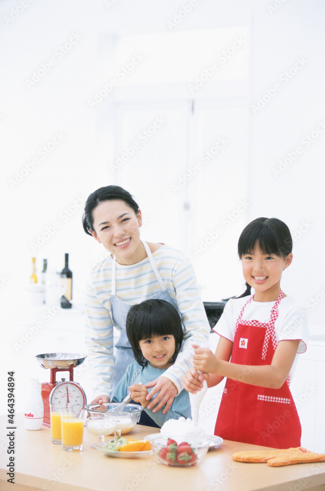 お菓子作りをする親子3人