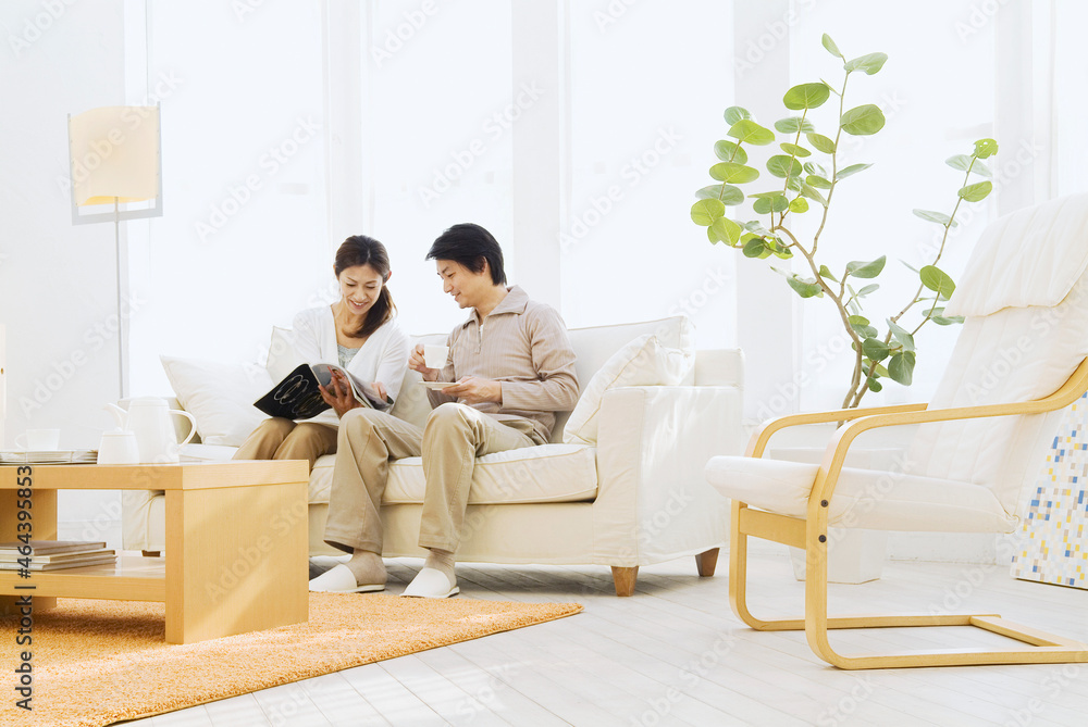 ソファでティータイム中の若夫婦 ソファでティータイム中の若夫婦