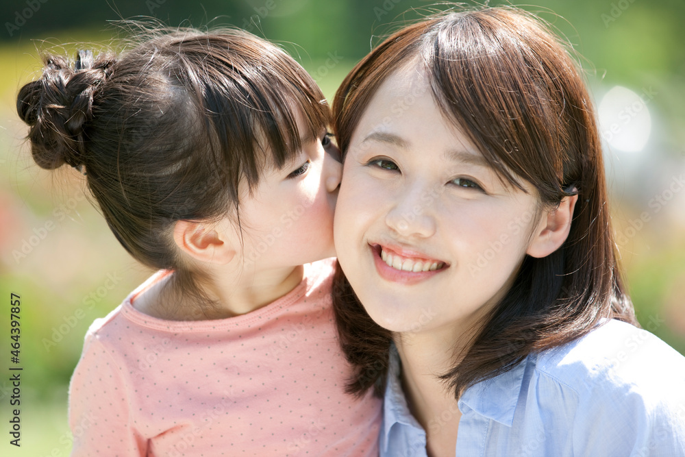 母親の頬にキスする女の子 母親の頬にキスする女の子