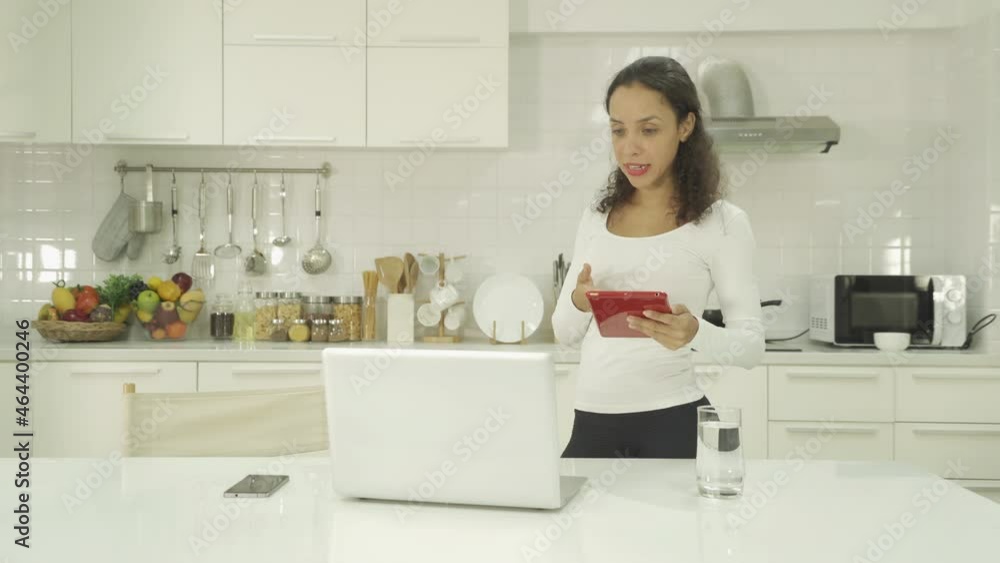 Portrait of happy smiling, latin woman talking, cooking food at home, video live on webcam video meeting with computer laptop, call conference, working online in kitchen. People lifestyle. Webinar Portrait of happy smiling, latin woman talking, cooking food at home, video live on webcam video meeting with computer laptop, call conference, working online in kitchen. People lifestyle. Webinar