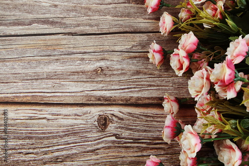 Pink roses flowers border frame on wooden background