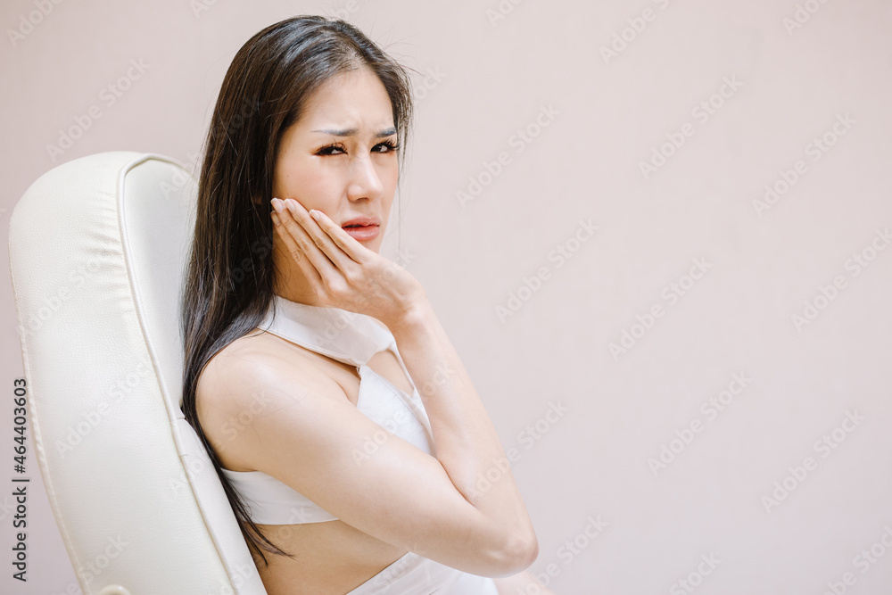 The beautiful woman touched her cheek, showing her toothache, and looked at the camera with a painful expression. The beautiful woman touched her cheek, showing her toothache, and looked at the camera with a painful expression.