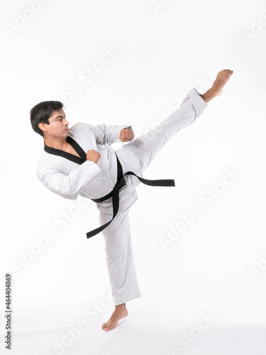 Taekwondo high kick - black belt taekwondo athlete martial arts master , handsome man show high kick pose during fighter training isolated on white background