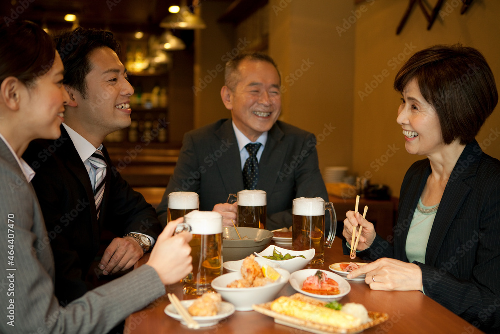 居酒屋で話をするビジネスマン4人