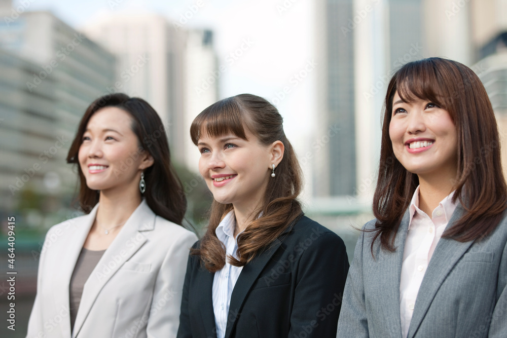笑顔で眺めるビジネスウーマン3人