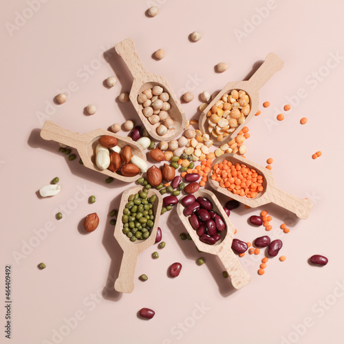 Vegan protein source. Beans, peas, chickpeas, lentils, mung bean, peanut in wooden spoon on beige background.