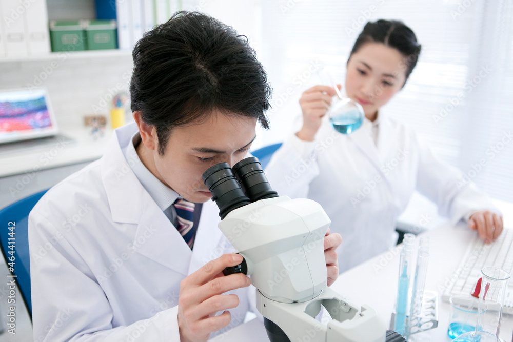顕微鏡を覗く研究員 顕微鏡を覗く研究員