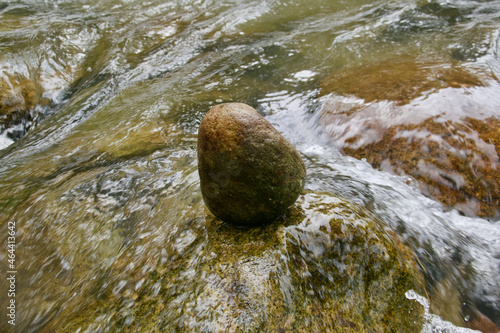 A stone or rock in balance in wild water