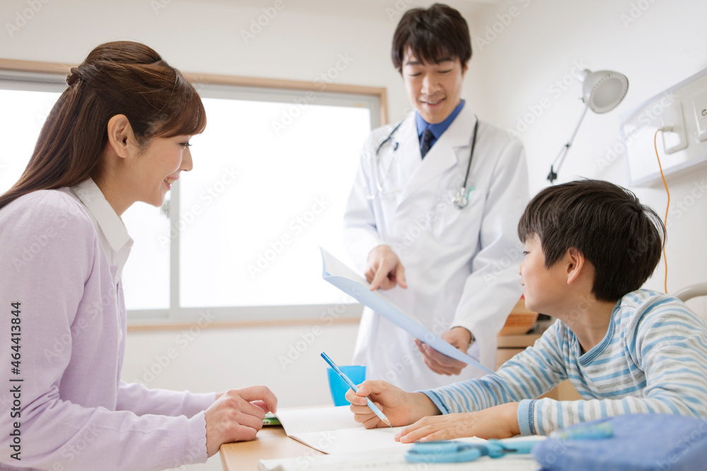 診察をする医師と患者と母親 診察をする医師と患者と母親