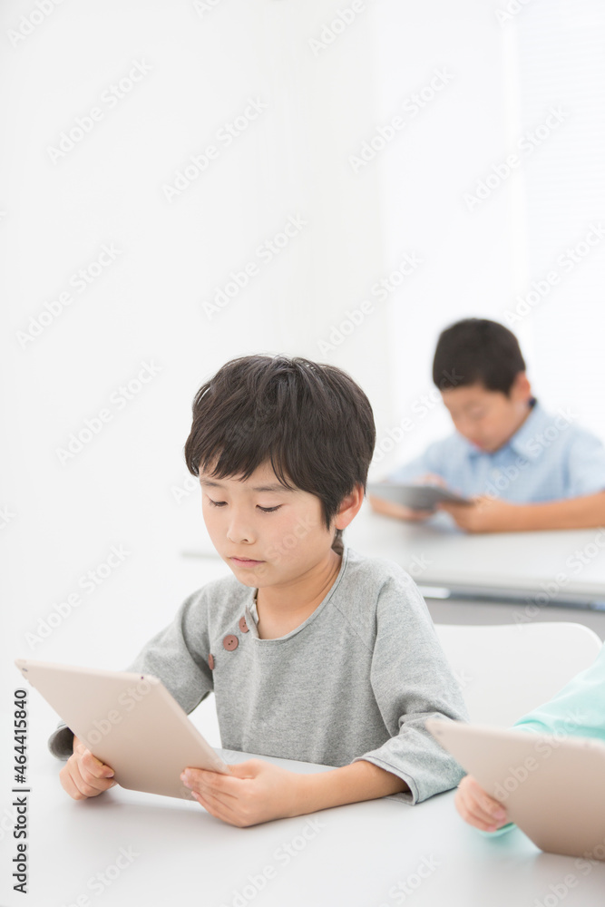 タブレットPCで勉強する小学生