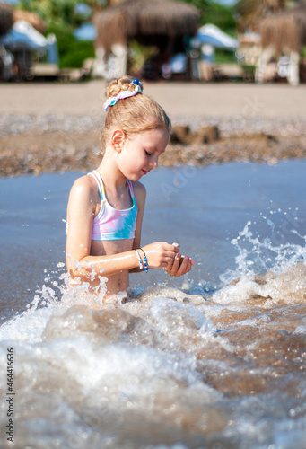 Fototapeta Naklejka Na Ścianę i Meble -  Little girl playing on the beach by the sea