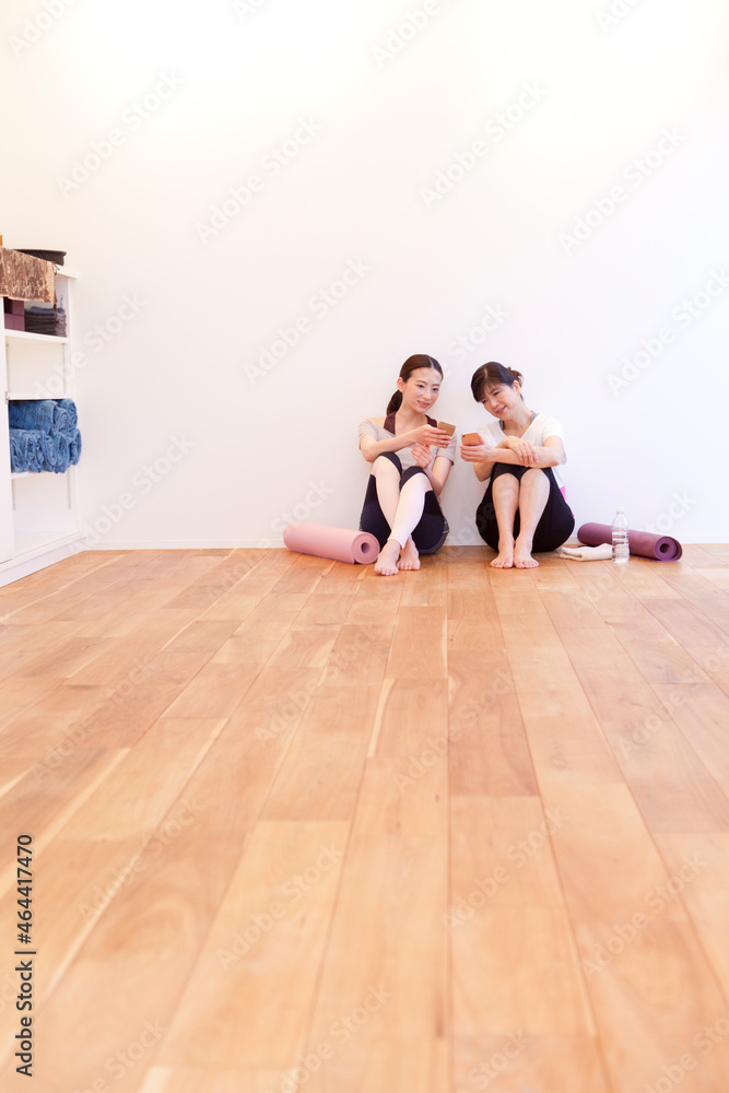 ヨガマットを持った2人の女性 ヨガマットを持った2人の女性