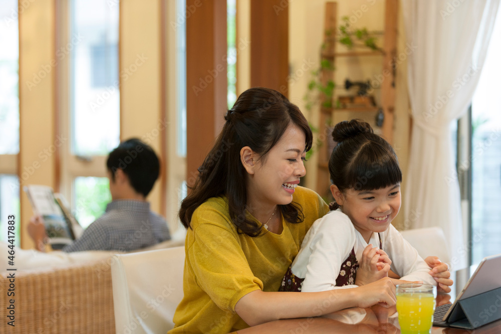 タブレットPCを見ている母と娘
