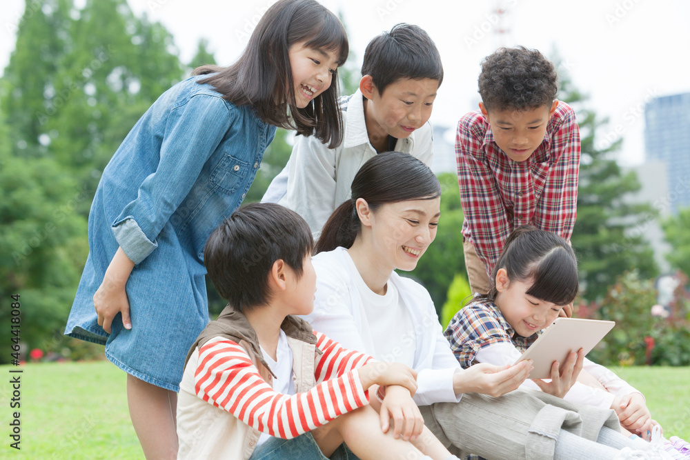 タブレットPCを見る小学生と先生