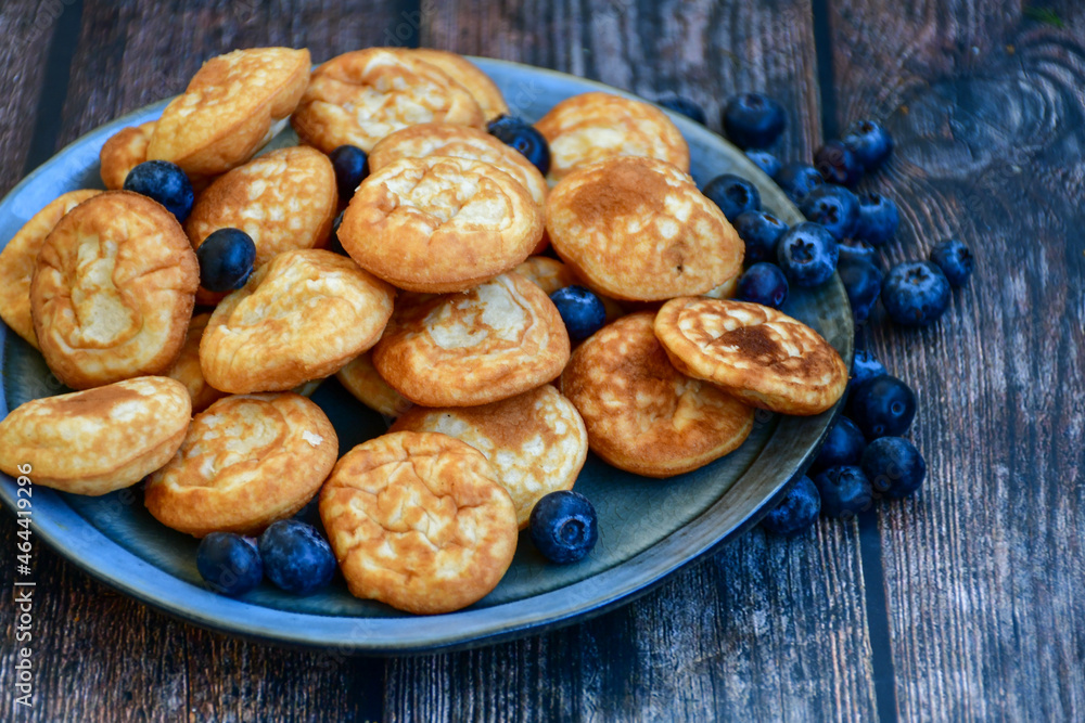 Homemade Dutch Poffertjes Mini Pancakes with butter , Powdered Sugar and blueberries Homemade Dutch Poffertjes Mini Pancakes with butter , Powdered Sugar and blueberries