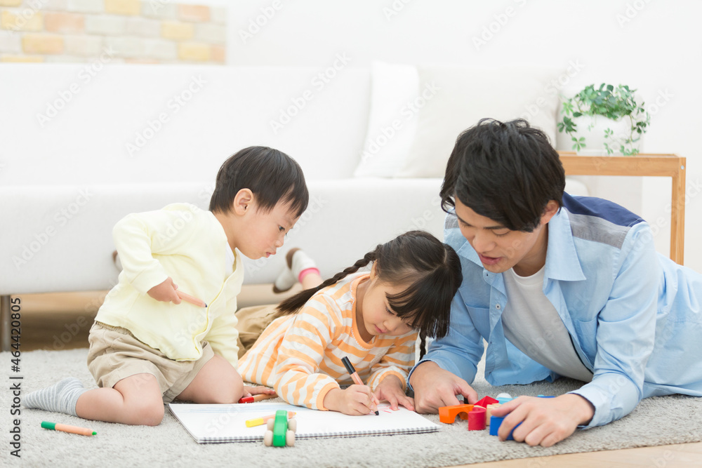 リビングで遊ぶ姉弟と父親 リビングで遊ぶ姉弟と父親