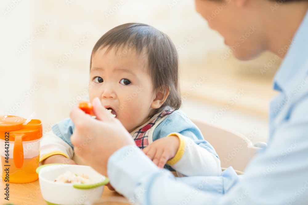 赤ちゃんにごはんを食べさせる父親 赤ちゃんにごはんを食べさせる父親