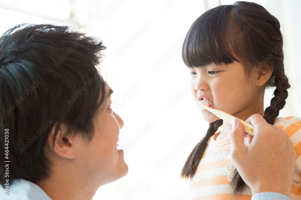女の子の歯磨きをしてあげる父親 女の子の歯磨きをしてあげる父親