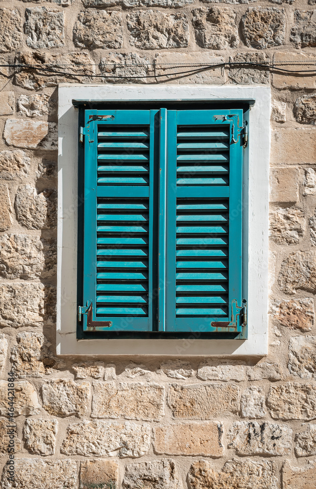 Fototapeta premium Old window with closed shutters on exterior wall of a house in Dubrovnik, Croatia.