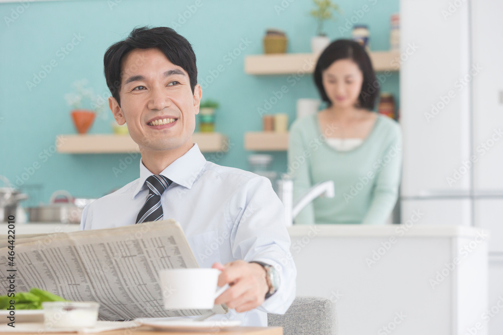 朝食中に新聞を読む男性と女性 朝食中に新聞を読む男性と女性