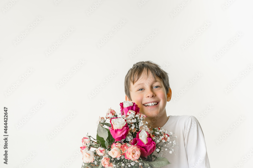 Cheerful eight-year-old boy holding a bouquet of flowers as a background for a greeting card with copy space Cheerful eight-year-old boy holding a bouquet of flowers as a background for a greeting card with copy space