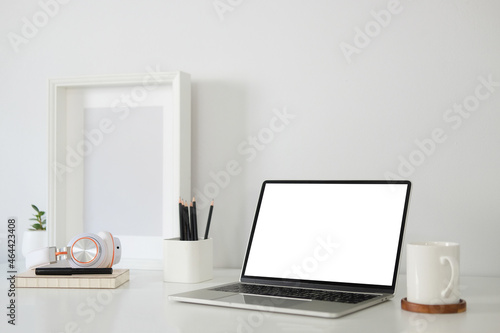  Modern workspace with computer with blank screen and equipment on white table.Blank screen for your information.