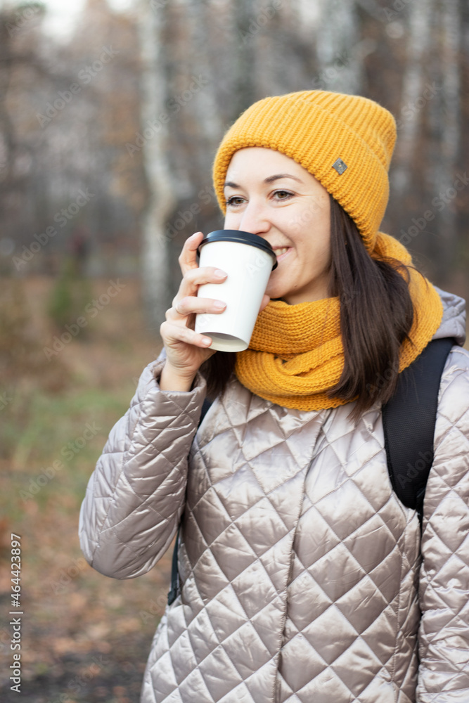 girl walks in the autumn park with a cup of coffee girl walks in the autumn park with a cup of coffee