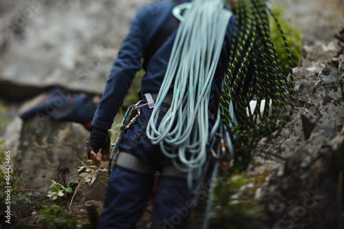 Silhouette of a rock climber with ropes, abstract unsharp image, rear view.