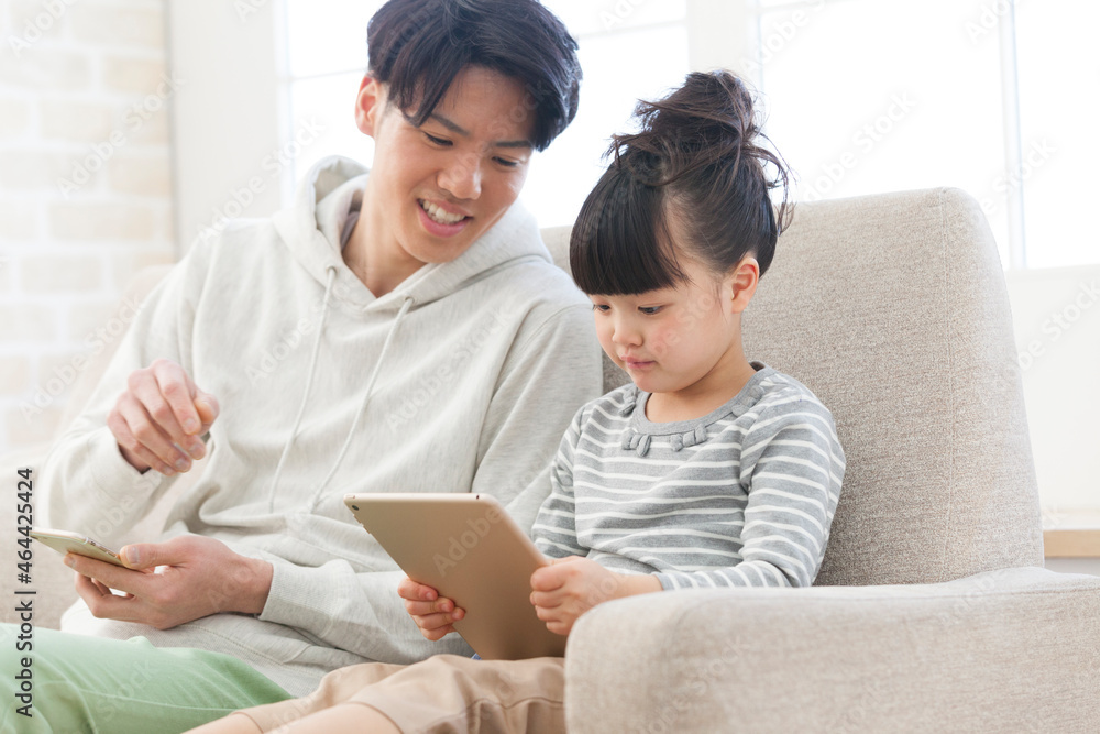 タブレットPCを見ている父娘