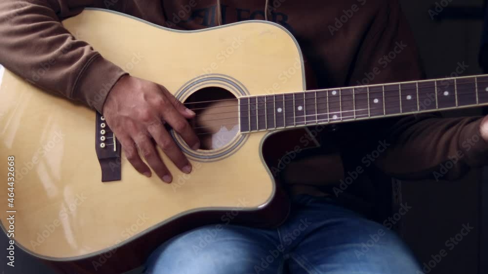 Man playing acoustic guitar in home. Man playing acoustic guitar in home.