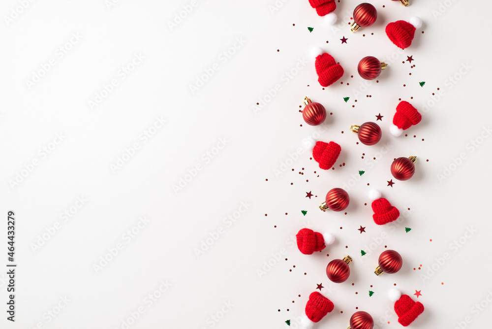 Top view photo of row composition red christmas tree decorations small balls bobble hats and multicolor confetti on isolated white background with empty space Top view photo of row composition red christmas tree decorations small balls bobble hats and multicolor confetti on isolated white background with empty space