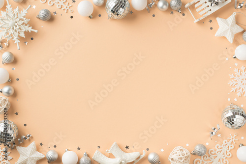 Top view photo of white and silver christmas tree decorations snowflakes stars disco balls confetti small ice skates sleigh and serpentine on isolated beige background with blank space in the middle