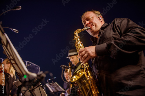 Male musician playing saxophone under blue night sky