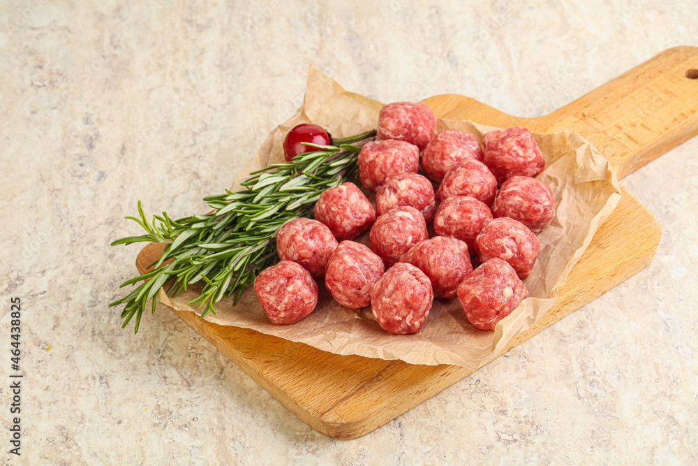 Raw uncooked beef meatballs served rosemary Raw uncooked beef meatballs served rosemary