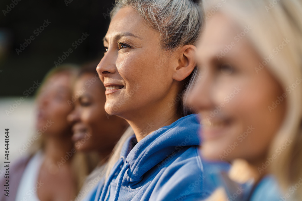 Multiracial women smiling and looking aside after yoga practice Multiracial women smiling and looking aside after yoga practice
