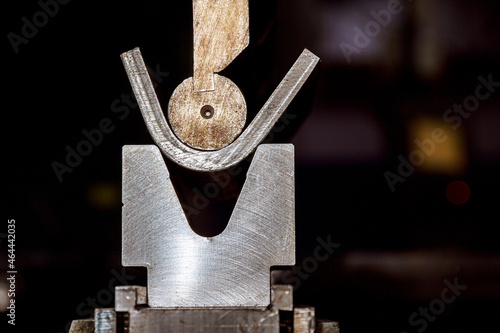 Work on a CNC bending machine in a factory. Sheet metal bending on a high-precision sheet metal bending machine. photo