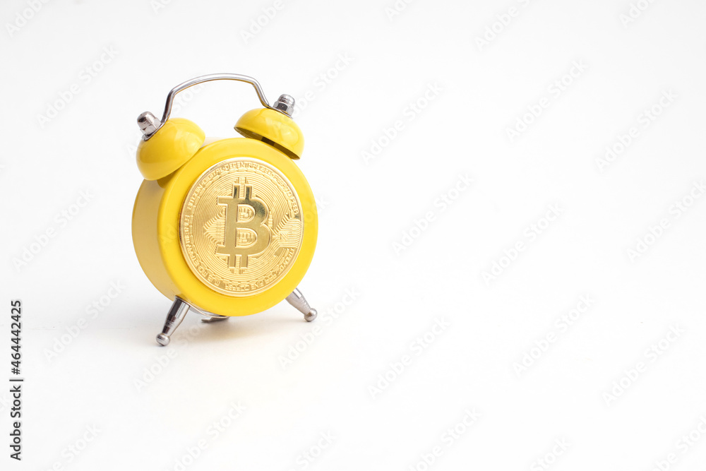 Yellow Alarm clock showing Bitcoin on display. Good time to earn and mining a crypto currency Yellow Alarm clock showing Bitcoin on display. Good time to earn and mining a crypto currency