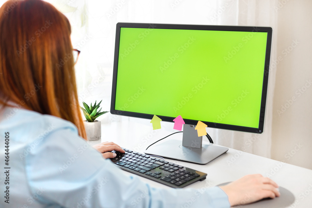 Close up of female hands and computer with green chromakey blank screen in modern office interior. Mock-up of computer monitor. Close up of female hands and computer with green chromakey blank screen in modern office interior. Mock-up of computer monitor.