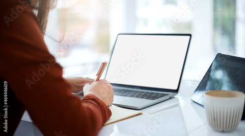Focus on hand young asian woman writing on book and using computer laptop and tablet working or study online