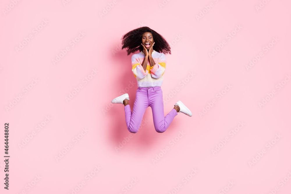 Full body portrait of astonished dark skin girl arms on cheeks open mouth isolated on pink color background Full body portrait of astonished dark skin girl arms on cheeks open mouth isolated on pink color background
