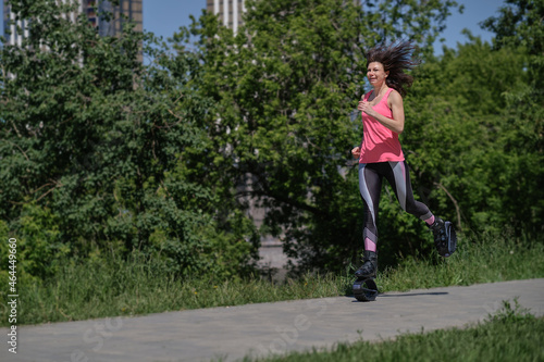 beautiful woman runs along the path in the park  legs in kangoo jumping shoes. women training Kangoo Jumping