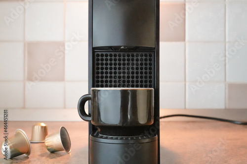 Black coffee capsule machine with cup and coffee pods