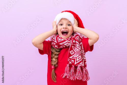 A little beautiful girl grabbed a New Year's hat and is very happy about the onset of the holidays.
