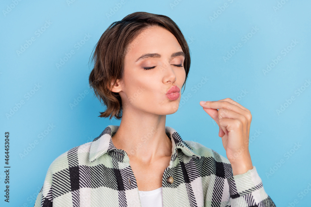 Photo of cute millennial brunette lady try food wear plaid shirt isolated on blue color background Photo of cute millennial brunette lady try food wear plaid shirt isolated on blue color background