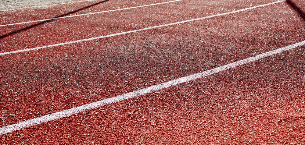 Fototapeta premium Red treadmill on sport field. Running track on the stadium