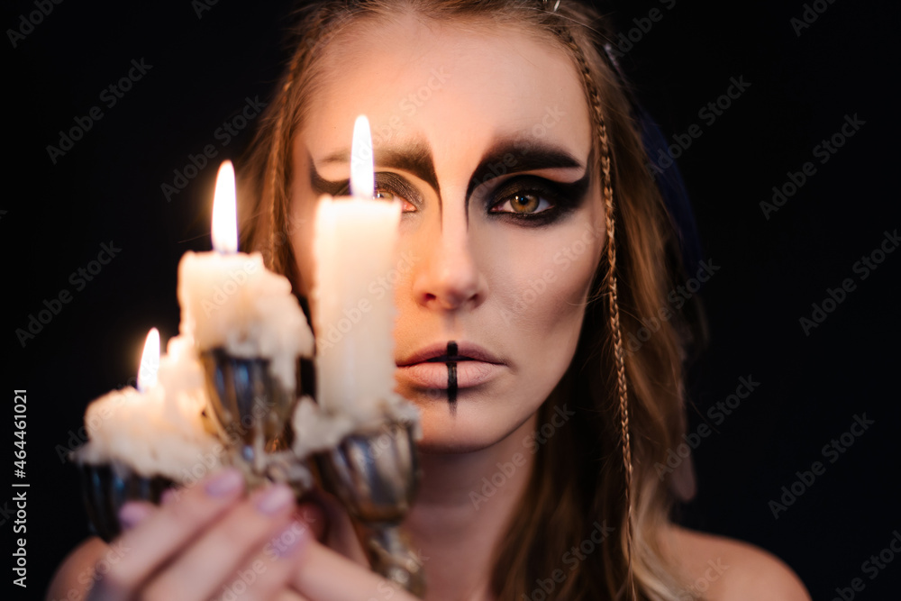 portrait of a witch with candle. Halloween mystical atmosphere. Celtic mythology goddess Valkyrie. Spiritualism spell rite. Masquerade makeup costume. Magic witchcraft occultism. Mystic mood lifestyle portrait of a witch with candle. Halloween mystical atmosphere. Celtic mythology goddess Valkyrie. Spiritualism spell rite. Masquerade makeup costume. Magic witchcraft occultism. Mystic mood lifestyle