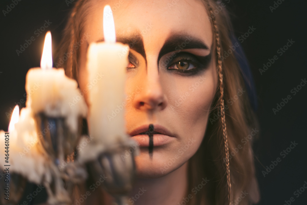 portrait of a witch with candle. Halloween mystical atmosphere. Celtic mythology goddess Valkyrie. Spiritualism spell rite. Masquerade makeup costume. Magic witchcraft occultism. Mystic mood lifestyle portrait of a witch with candle. Halloween mystical atmosphere. Celtic mythology goddess Valkyrie. Spiritualism spell rite. Masquerade makeup costume. Magic witchcraft occultism. Mystic mood lifestyle